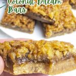 coconut dream bar with a bite taken out on a blue napkin.