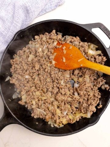 browned ground beef and onions in a cast iron skillet.