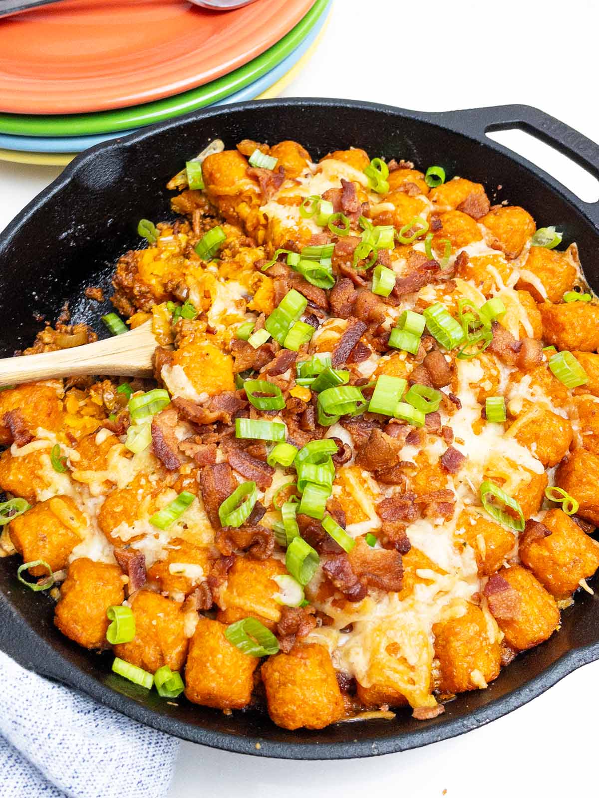 sweet potato cheeseburger tater tot casserole in a cast iron skillet.