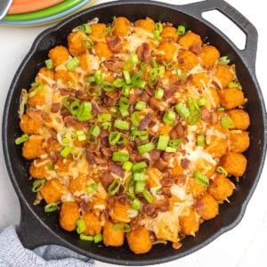 sweet potato cheeseburger tater tot casserole in a cast iron skillet.
