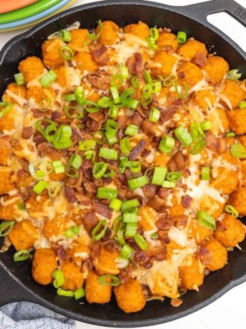 sweet potato cheeseburger tater tot casserole in a cast iron skillet.