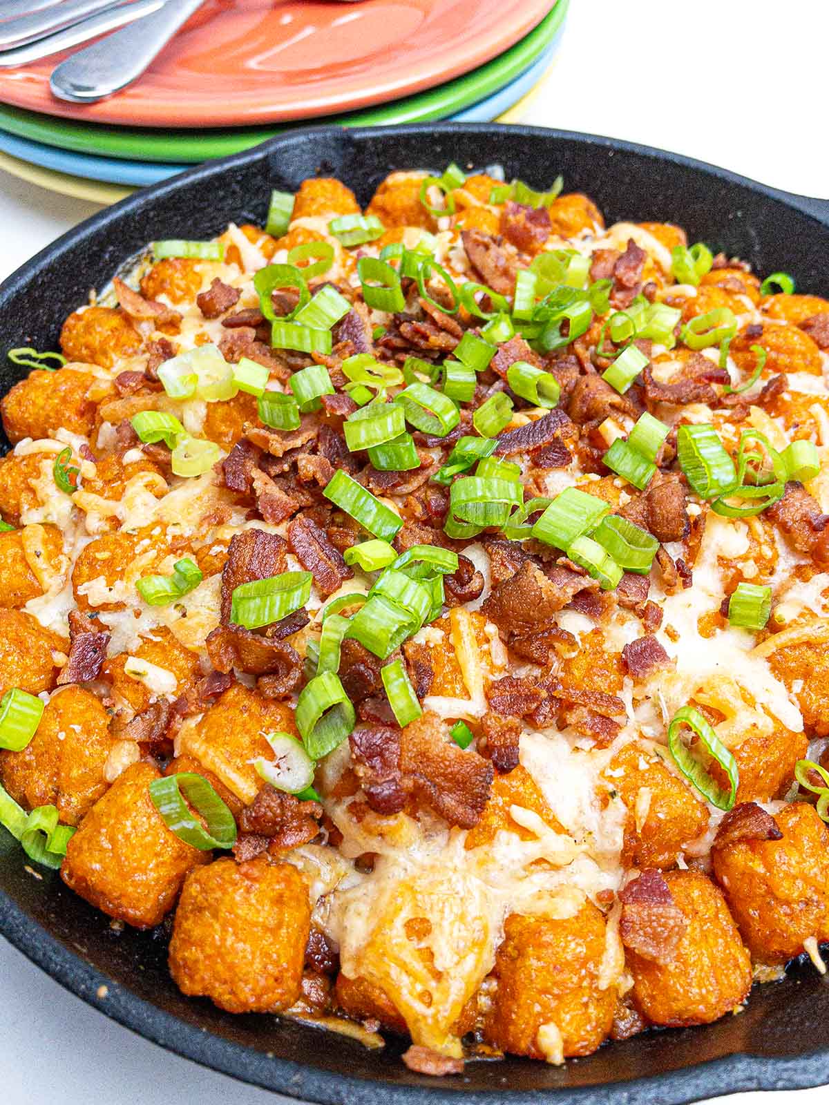 sweet potato cheeseburger tater tot casserole in a cast iron skillet.