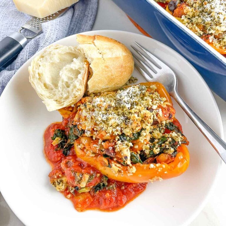 a vegetarian Italian stuffed pepper on a white plate with bread.