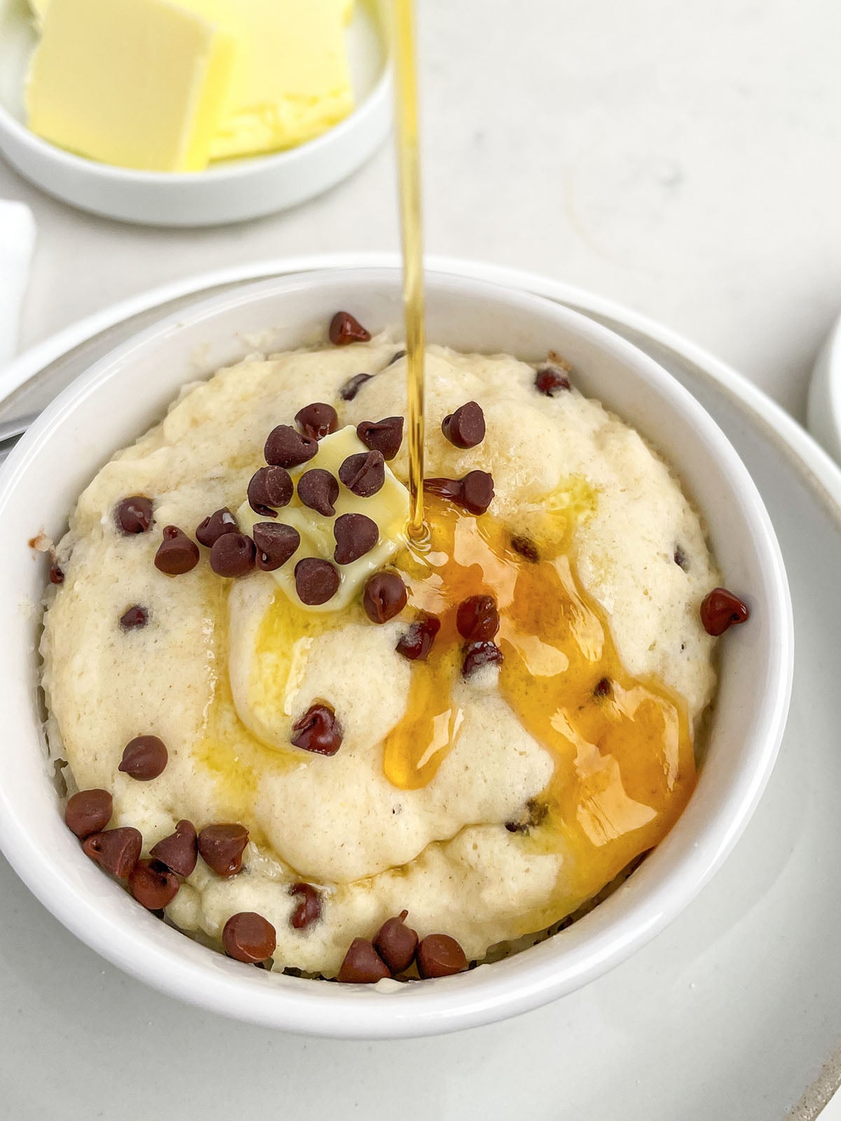 chocolate chip pancake in a mug with maple syrup.