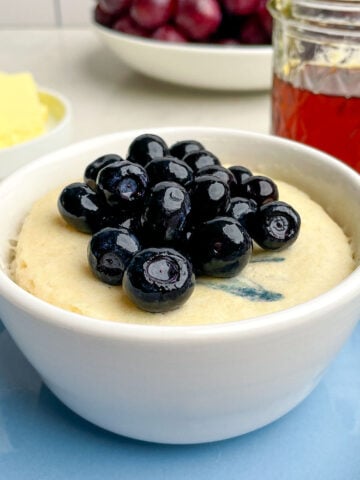 blueberry pancake in a mug topped with blueberries.