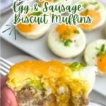 hand holding a sausage egg and biscuit muffin with a bite taken out.