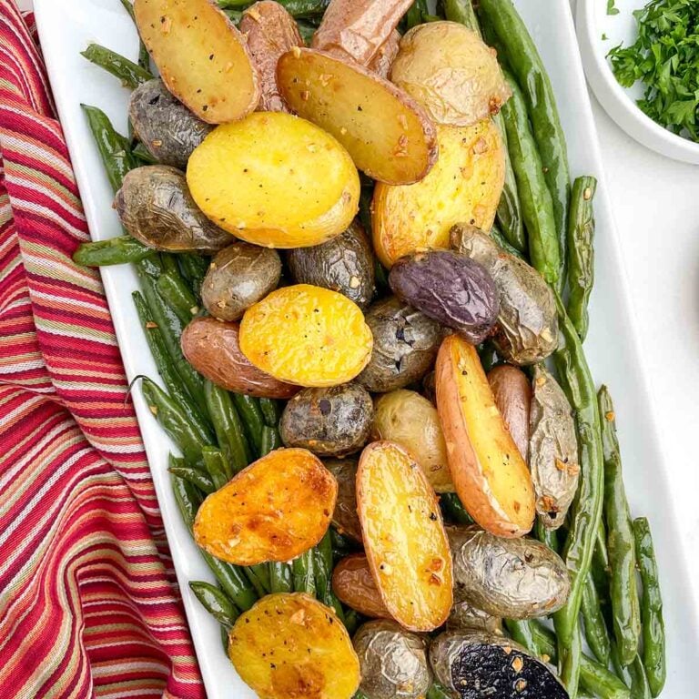 roasted green beans and potatoes on a white platter.