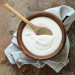 yogurt in wooden bowl with wooden spoon