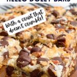 hello dolly bars cut into squares on a wooden cutting board.