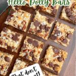 hello dolly bars cut into squares on a wooden cutting board.