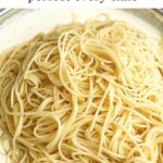spaghetti in a pot of alfredo sauce.