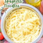 a colander of cooked spaghetti on a red and white checkered tablecloth.