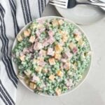 English pea salad in a white bowl on a white countertop