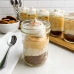 a pumpkin pie in a cup with a spoon in front of jars of pumpkin pie in a cup