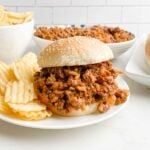 chicken gumbo sloppy joe on a white plate with potato chips