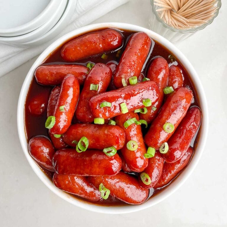 lil smokies with grape jelly and bbq sauce in a white bowl