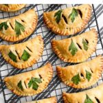 baked vegetarian empanadas on a wire rack.