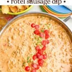 Sausage Rotel dip in a skillet next to Fritos and plates.