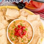 Sausage Rotel dip in a bowl on a plate of tortilla chips.