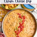 Sausage Rotel dip in a skillet next to Fritos and plates.