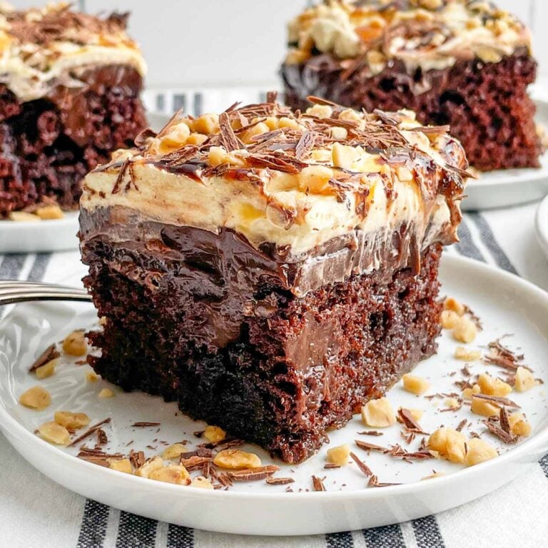 a piece of chocolate caramel poke cake on a white plate.