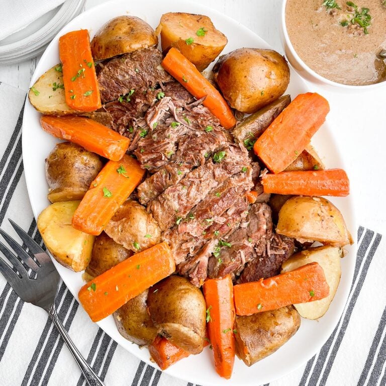 pot roast with onion soup mix, potatoes, and carrots on a white platter