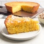 piece of Jiffy sweet corn bread on white plate topped with cinnamon honey butter and honey