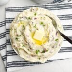 garlic redskin mashed potatoes in a white bowl on a black and white napkin