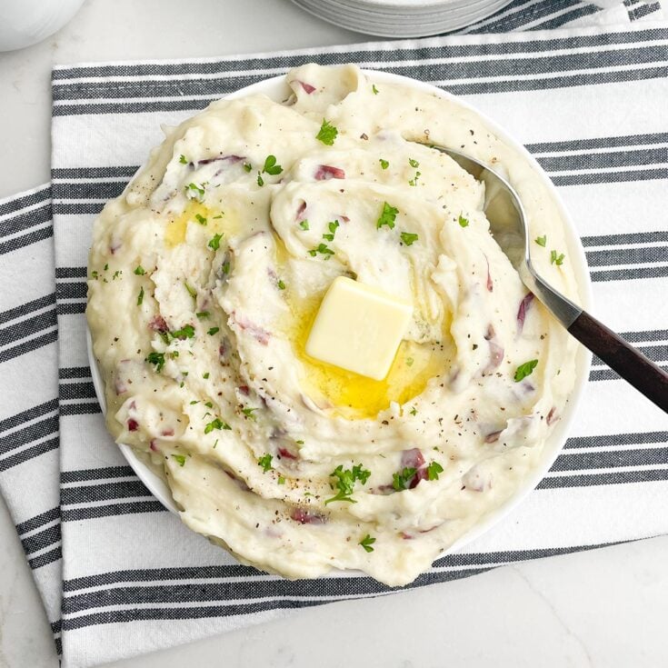 garlic redskin mashed potatoes in a white bowl on a black and white napkin