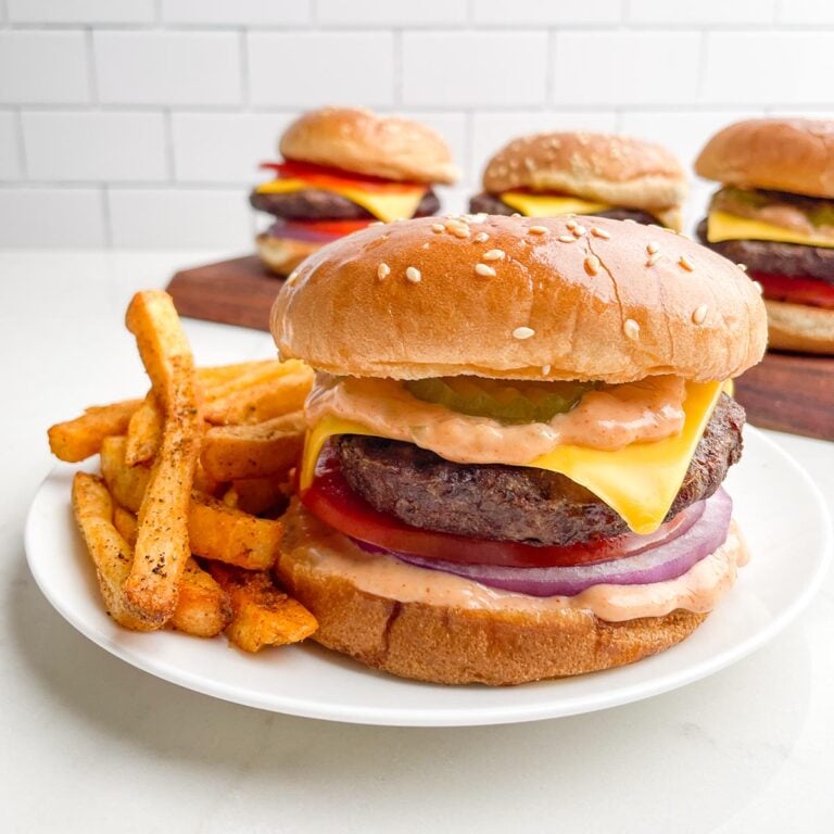 Cheeseburger with McDonald's Big Mac sauce and fries on a white plate