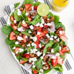 strawberry goat cheese salad on a white platter