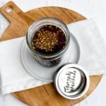 teriyaki marinade in a mason jar on a white plate and white napkin on a wooden cutting board