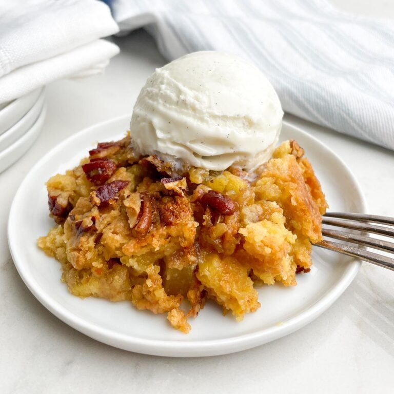 pineapple dump cake and ice cream on a white plate