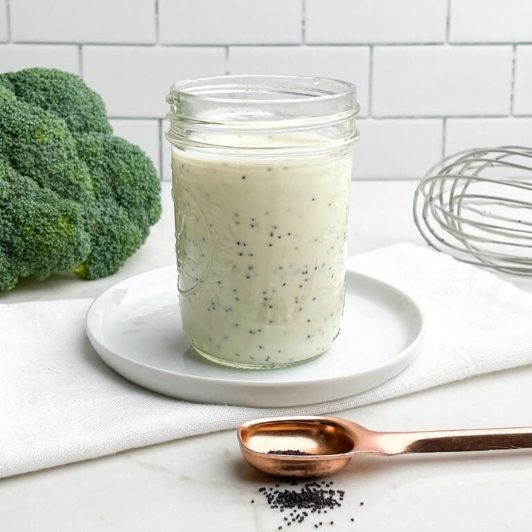 honey poppyseed dressing in a mason jar on a white plate