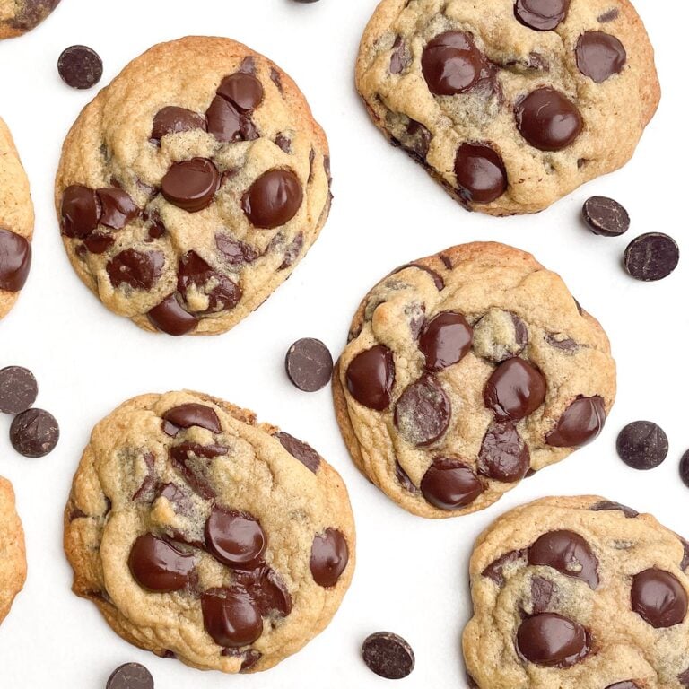 chocolate chip cookies and chocolate chips on white parchment