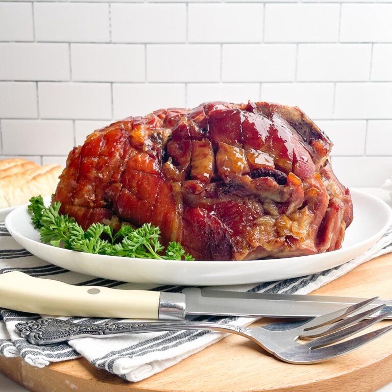 glazed roaster oven ham on a white platter