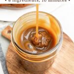 spoon drizzling caramel sauce without cream into a mason jar.