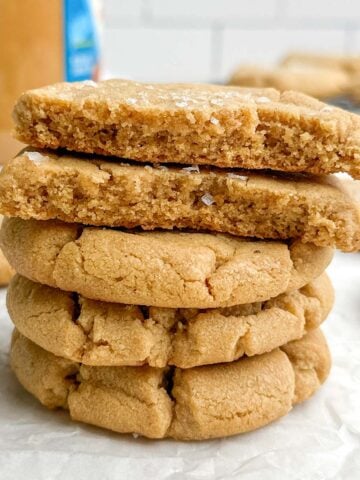 a stack of brown butter peanut butter cookies on parchment paper.