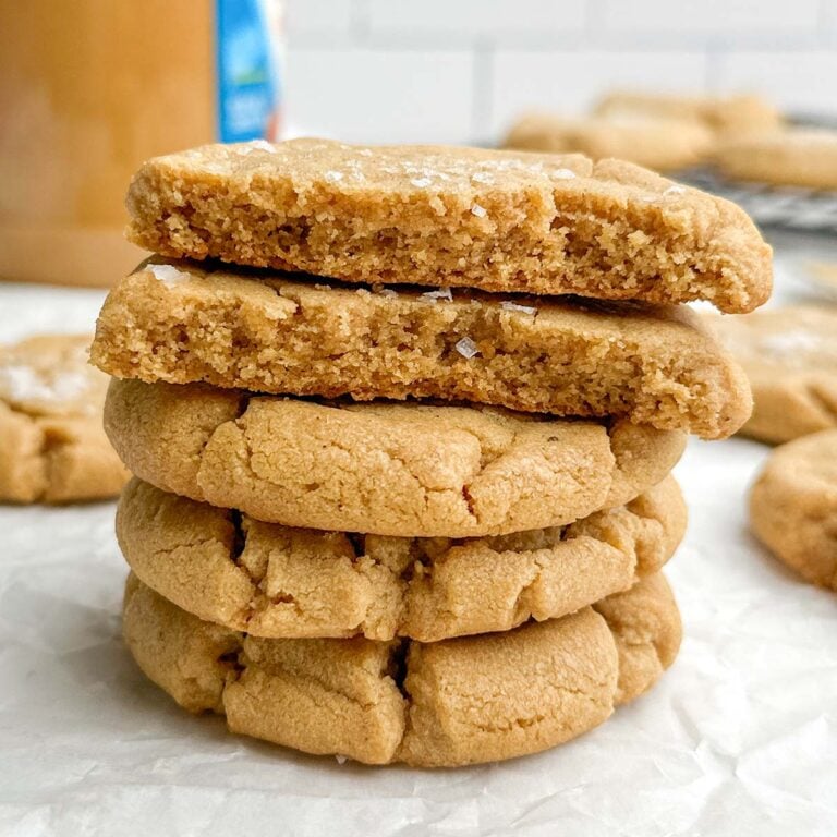 a stack of brown butter peanut butter cookies on parchment paper.