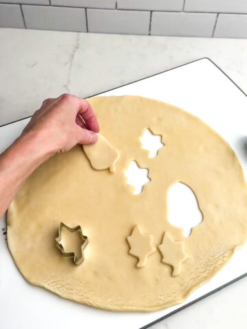 cutting shapes out of pie dough with a cookie cutter.