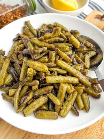 sauteed canned green beans in a white bowl.