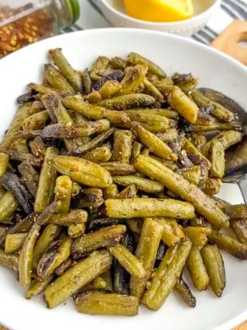 sauteed canned green beans in a white bowl.