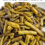 sauteed canned green beans in a white bowl.