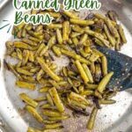 sauteed canned green beans in a stainless steel skillet.