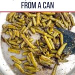 sauteed canned green beans in a stainless steel skillet.