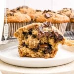 banana chocolate chunk muffin half on a white plate.