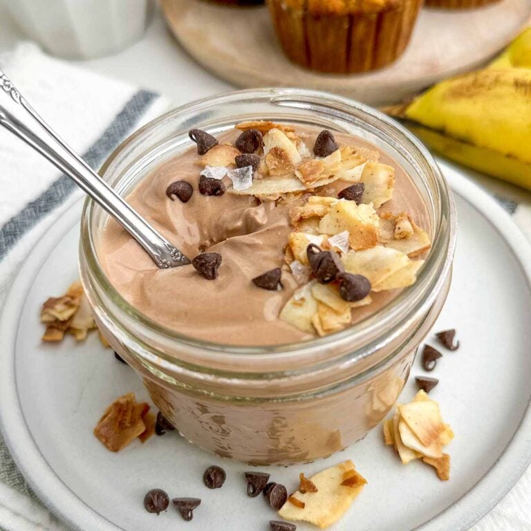 coffee yogurt topped with coconut, almonds, and chocolate chips in a mason jar.