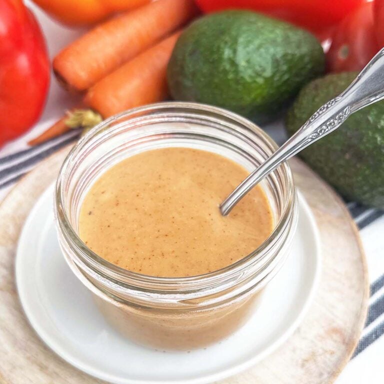 bbq ranch dressing in a mason jar surrounded by fresh vegetables.