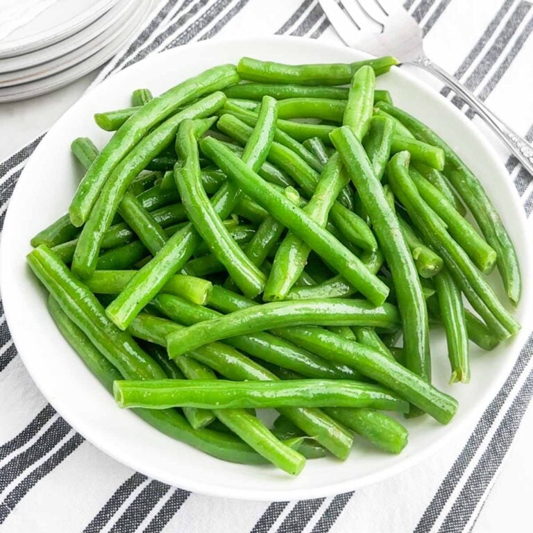 microwave steamed green beans in a white bowl.
