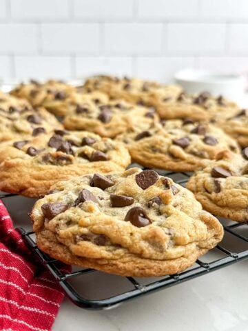 bakery style chocolate chip cookies on a wire baking rack.